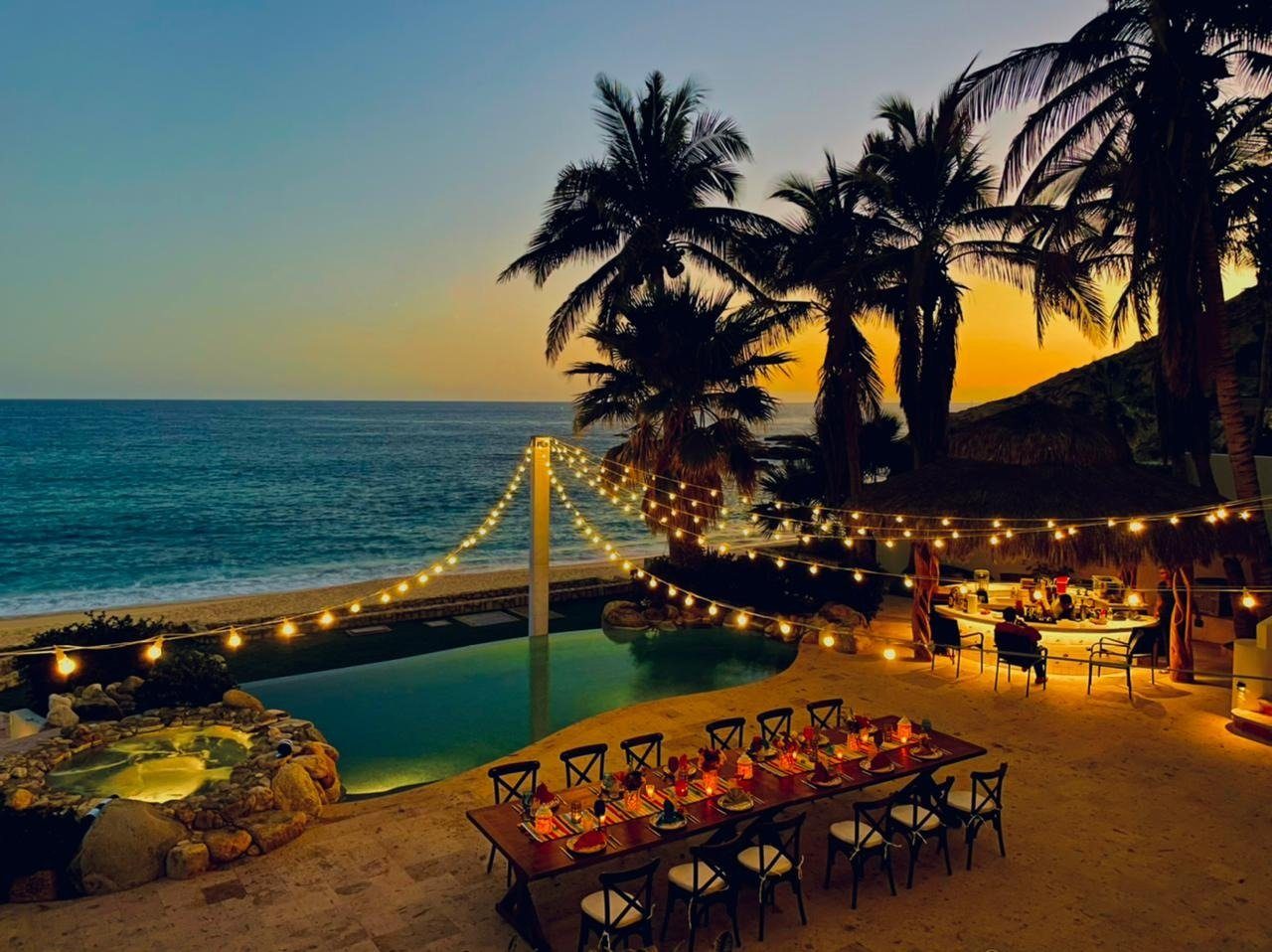 Dinner table by an infinity pool at sunset
